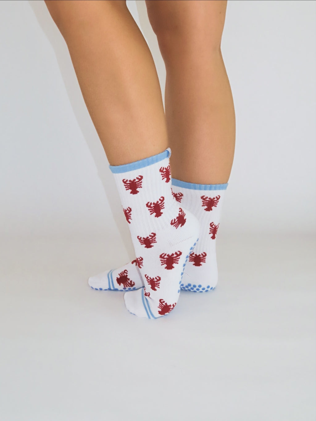 Lobster Roll grip socks on feet, standing